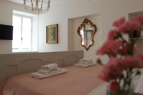 einen Salon mit zwei Masseusen auf einem Bett mit Spiegel in der Unterkunft Agritur Cantina Romanese in Levico Terme