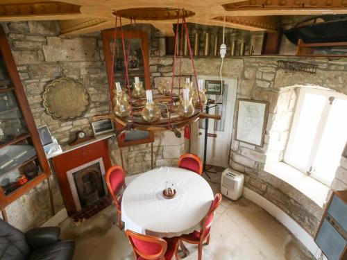 a table and chairs in a room with a stone wall at Old Higher Lighthouse Stopes Cottage in Southwell