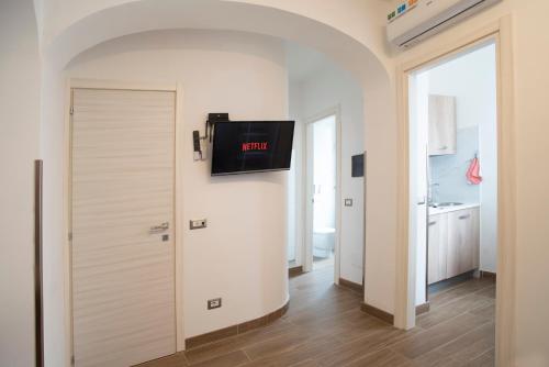 Zimmer mit einer Tür und einem TV an der Wand in der Unterkunft Il Vicoletto sul Mare in Ischia