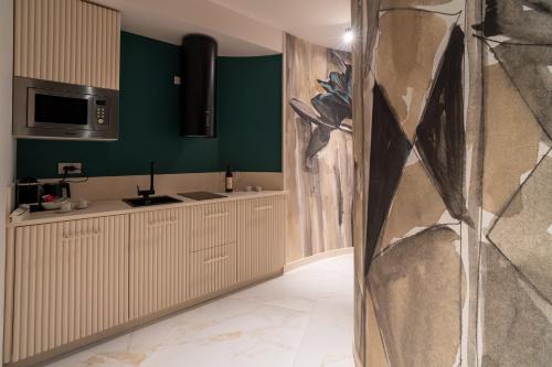 a kitchen with green walls and a counter top at Lilyum in Cagliari