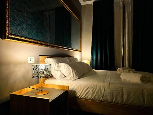 1 dormitorio con 1 cama con lámpara y una foto en MIRA Apartment, en Catania