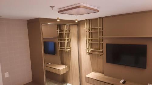 a hotel room with a tv and a room with at I Am Design Hotel Itapema by Hotelaria Brasil in Itapema