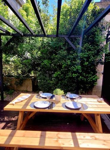- une table en bois avec des assiettes et de la vaisselle dans l'établissement Joli duplex avec terrasse et parking, à La Rochelle