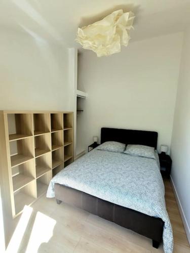 - une chambre avec un lit et quelques étagères dans l'établissement Joli duplex avec terrasse et parking, à La Rochelle