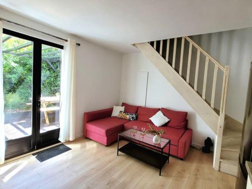 - un salon avec un canapé rouge et un escalier dans l'établissement Joli duplex avec terrasse et parking, à La Rochelle