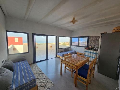 阿加迪尔apartment vue Mer的一间带桌子的客厅和一间带窗户的厨房