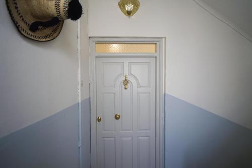 Eine weiße Tür mit einem goldenen Türknauf drauf. in der Unterkunft Dar Badr in Tangier
