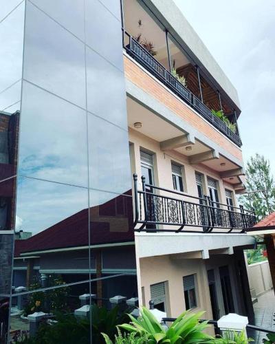 un reflet d'un bâtiment avec un balcon. dans l'établissement Ally Ngali, à Kigali