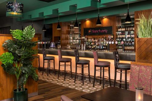 a bar with a row of stools in a restaurant at Crowne Plaza Dublin Blanchardstown by IHG in Blanchardstown