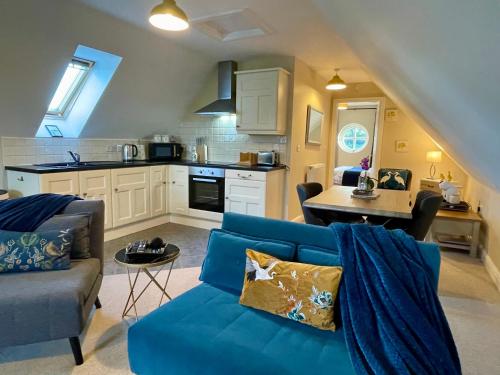 a living room with a blue couch and a kitchen at Cheshire Retreat at Within Street Farm in Middlewich