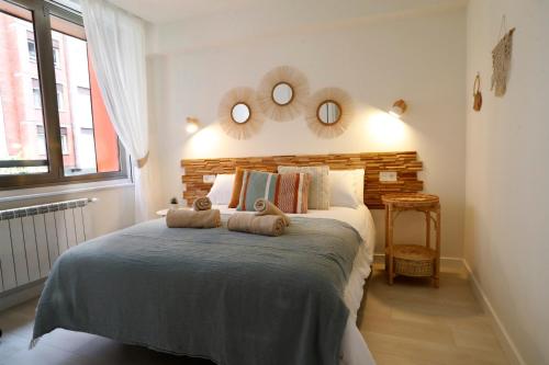 Un dormitorio con una cama con dos toallas encima. en EL ENCANTO DEL CENTRO, en Gijón