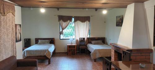 Habitación con 2 camas y TV. en Campestre Saraguros en Cuenca