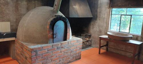 un horno de ladrillo en una cocina con fregadero en Campestre Saraguros en Cuenca