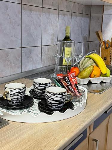 a kitchen counter with a bunch of dishes and fruit at Pougarka Apartments in Jajce