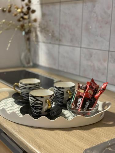 a tray with coffee cups and packets on a kitchen counter at Pougarka Apartments in Jajce
