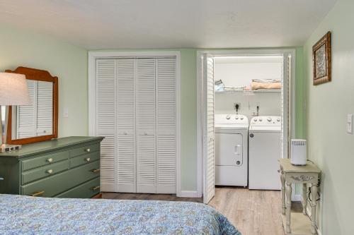 a bedroom with a bed and a sink and a refrigerator at Cottage on Private Pond with Beach in Wareham in Wareham