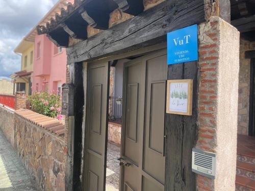 un edificio con dos puertas de garaje y un cartel en él en Casa La Divisa, en Boceguillas