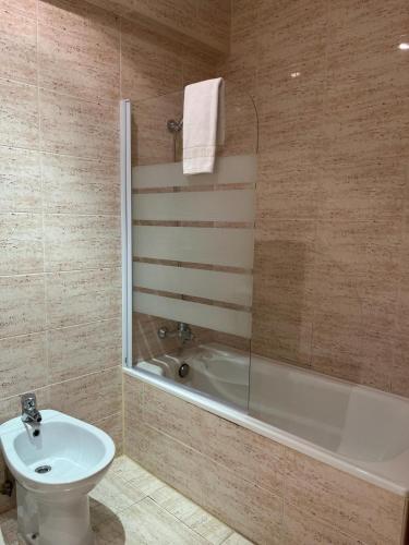 y baño con bañera, aseo y lavamanos. en Fleming Center by Punta 25 Hotels Group, en Benidorm