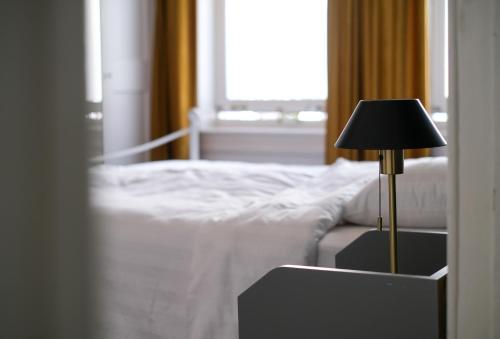 a bedroom with a bed and a lamp on a table at Your homestay in a bibliophile mansion in Antwerp