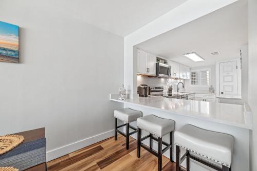 eine Küche mit einer großen weißen Theke und Stühlen in der Unterkunft Edgewater West Unit 44 in Gulf Shores