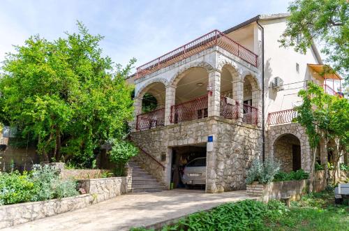 an old stone house with a balcony and a car at Rooms Ante in Vrboska