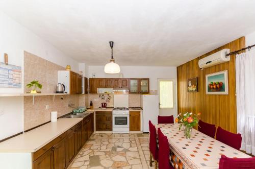 a kitchen with a table with red chairs and a tableablish at Rooms Ante in Vrboska