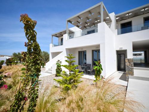 a white house with plants in the foreground at Paros Gem in Naousa