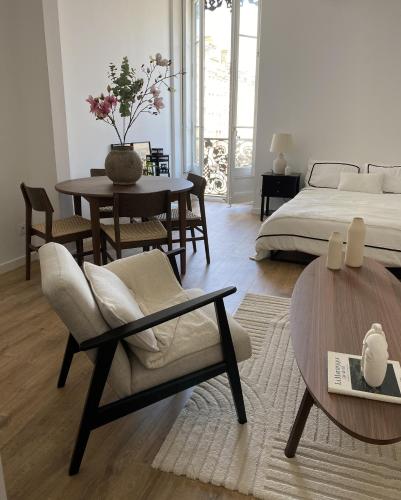 un salon avec un lit, une table et des chaises dans l'établissement Vue Place des Terreaux-4 Voyageurs, à Lyon