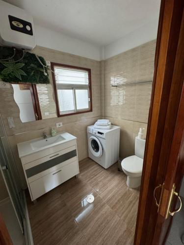 a bathroom with a toilet sink and a washing machine at Juanita Flat in Tazacorte