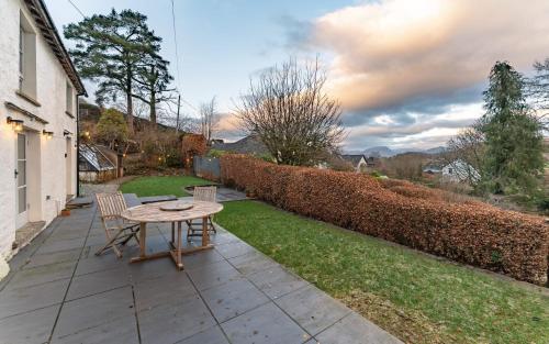 a patio with a table and chairs in a yard at Longcroft in Hawkshead