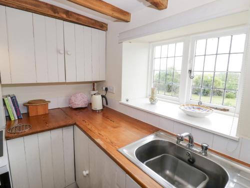 a kitchen with white cabinets and a sink at Priors Mead in Banbury