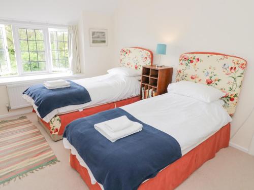 a bedroom with three beds and a window at Priors Mead in Banbury