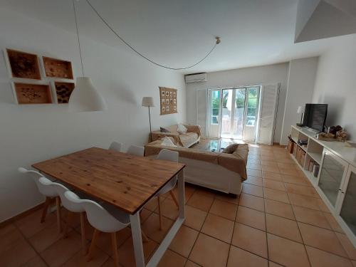 una sala de estar con una mesa y un sofá en Casa Água & Sal, en Praia Verde