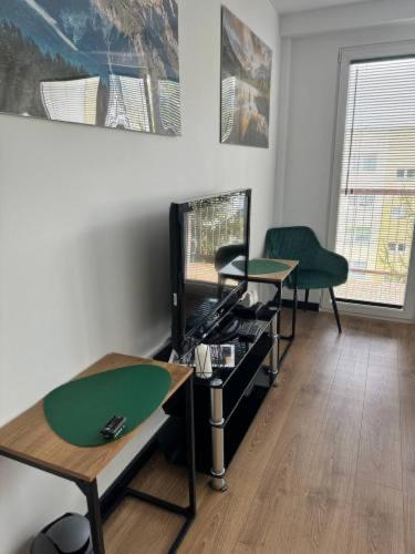 a living room with two tables and a television at Na Szczycie in Chełm