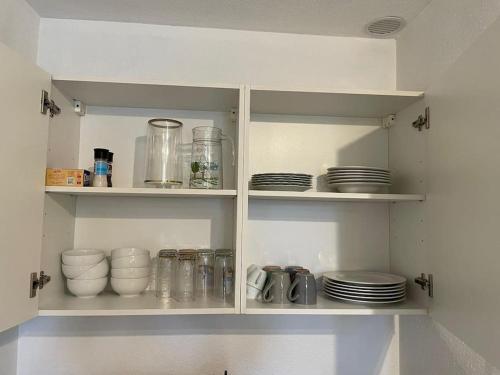 a white cabinet with plates and dishes in it at Appartement route du vin in Dambach-la-Ville