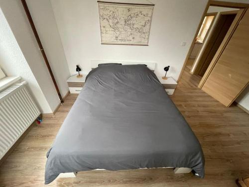 Cette chambre comprend un grand lit et 2 tables. dans l'établissement Appartement route du vin, à Dambach-la-Ville