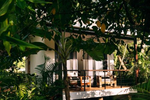 a house with a balcony with chairs and a tree at La Prometida in Puerto Viejo