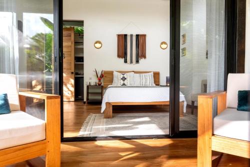a bedroom with a bed and a living room at La Prometida in Puerto Viejo