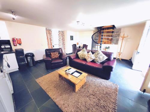 een woonkamer met banken en een salontafel bij Dolgun Uchaf Guesthouse and Cottages in Snowdonia in Dolgellau