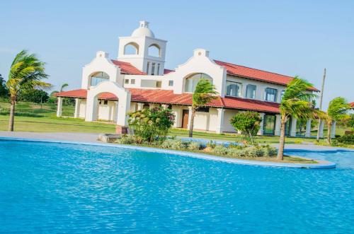 a large white building with a clock tower next to a swimming pool at 3-Bedroom Condo in a Golf Course in Santa Cruz de la Sierra