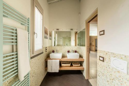 a bathroom with two sinks and a mirror at Villa Il Fico in Cavriglia