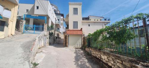 una calle vacía con un edificio y una valla en Villa Sotiri en Sarandë