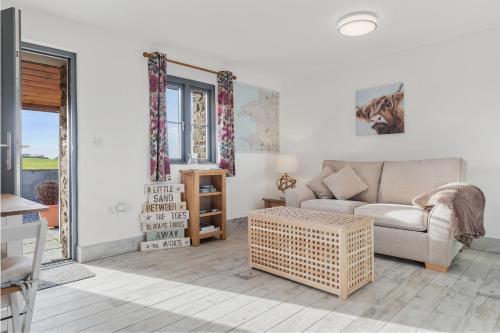 a living room with a couch and a table at Grassholm Cottage with Hot Tub - Dog Friendly in Haverfordwest