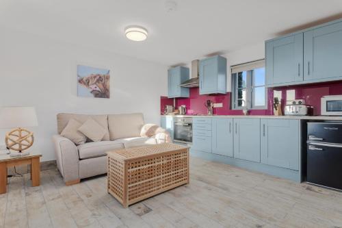 a living room with a couch and a kitchen at Grassholm Cottage with Hot Tub - Dog Friendly in Haverfordwest