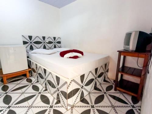 a room with a bed and a tv on a table at Pousada Paraíso in Novo Airão
