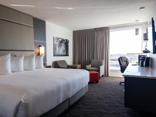 ein Hotelzimmer mit einem großen Bett und einem Fenster in der Unterkunft Carriage House Hotel and Conference Centre in Calgary