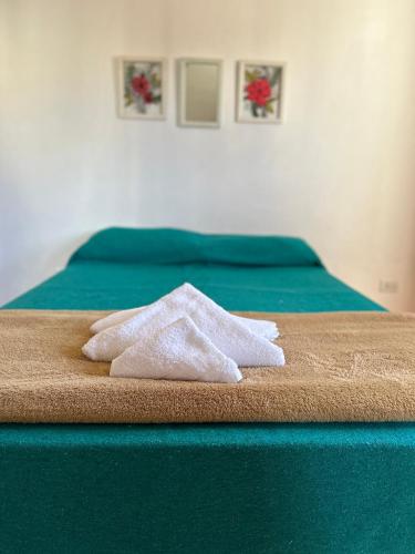 une pile de serviettes assises au-dessus d'un lit dans l'établissement casa Bella, à Deán Funes