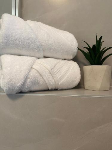 a stack of towels on a shelf in a bathroom at Apartman Rawda 1 in Jajce