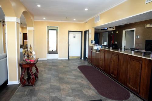 a large kitchen with wooden cabinets and a table at Baymont Inn & Suites in Manning