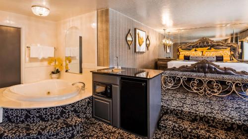 a large bathroom with a tub and a bed at Best Western Coral Hills in St. George